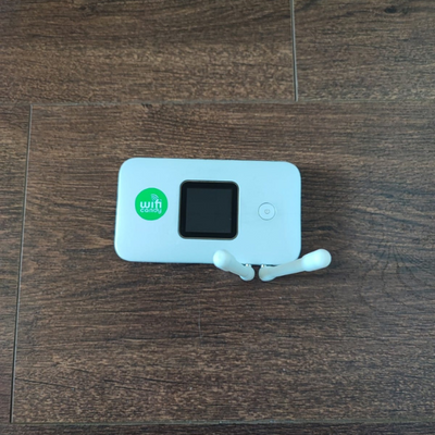 Boostercandy networking device featuring a green branding sticker on a brown table