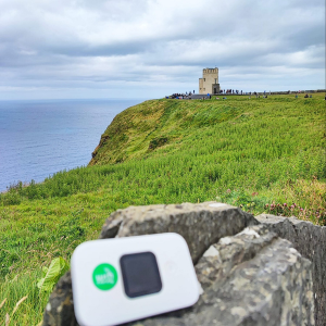 Compact portable WiFi device placed atop a rock beside the sea at the Cliffs of Moher